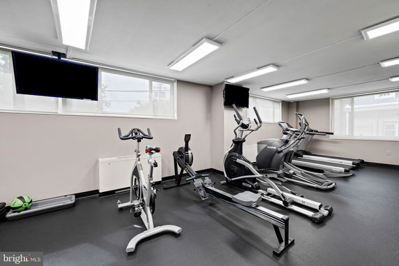 Indoor gym area with exercise equipment including treadmills, stationary bike, and rowing machine.