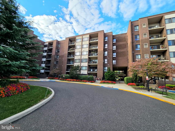 Front view of a multi-story apartment building with balconies.
