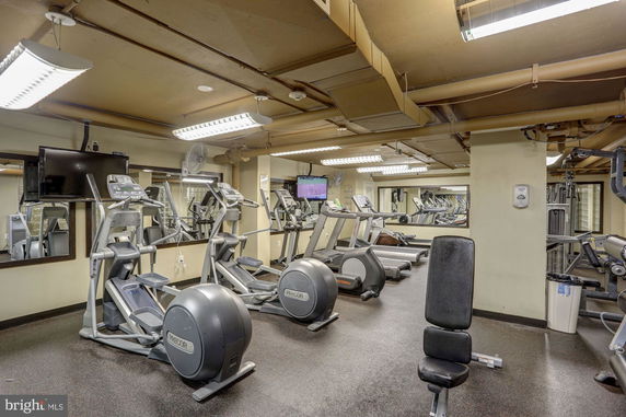 Indoor gym with exercise equipment including treadmills and elliptical machines.