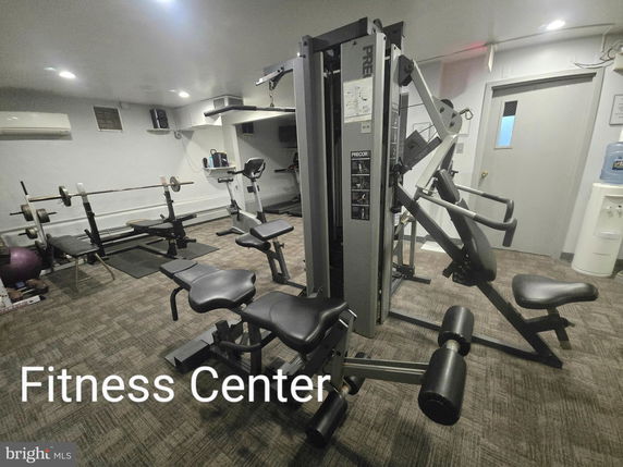 Room equipped with gym fitness equipment including machines and weights.
