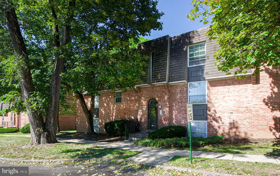 Front view of a brick two-story building with large windows and a slightly sloped roof.
