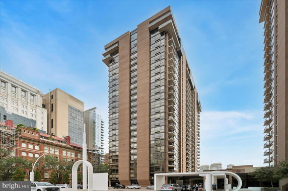 Front view of a tall modern building with large windows and balconies.