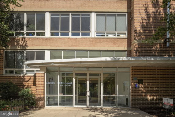 Front view of a multi-story building with large windows and a glass entrance.