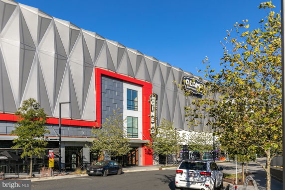 Front view of a large commercial building with geometric facade and signage.