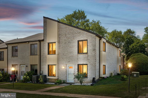 Front view of a two-story townhouse with large windows.