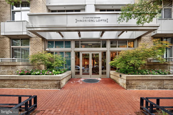 Front view of a modern building entrance with brick and glass facade.