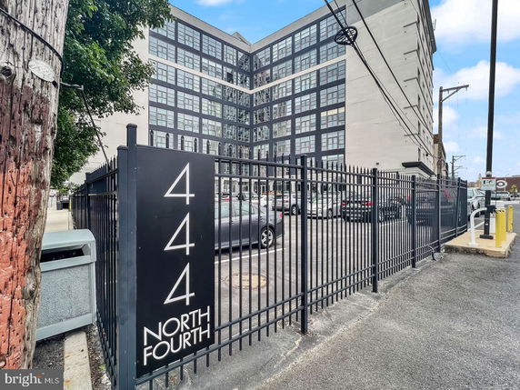 Front view of a multi-story building with large glass windows and a gated entrance.