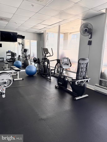 Indoor gym area with exercise equipment and large windows.