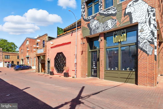 Front view of a building with painted murals and large windows.