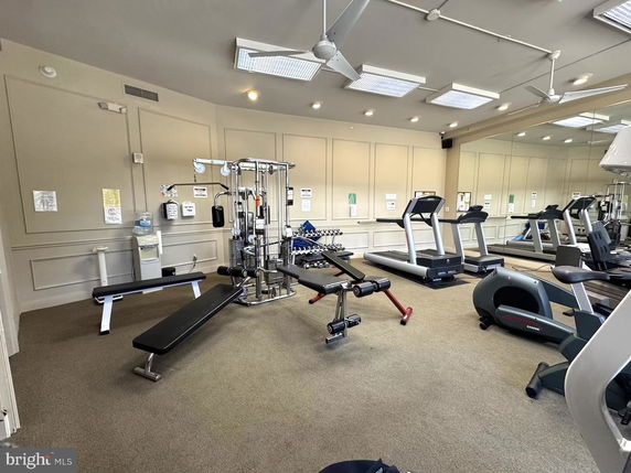 Indoor gym area with exercise equipment including treadmills, benches, and machines.