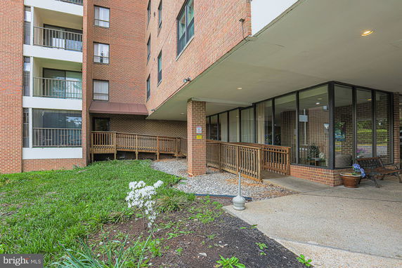 Front view of a multi-story brick building with balconies and a glass-enclosed area.