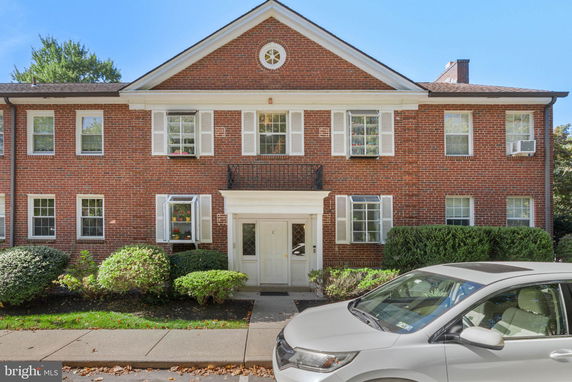 Front view of a two-story brick building with white trim and multiple windows.