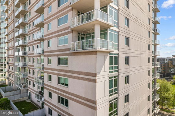 Front view of a multi-story apartment building with balconies.