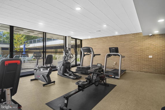Indoor gym area with exercise equipment and large windows.
