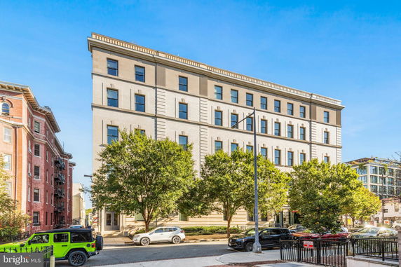 Front view of a multi-story building with numerous windows and decorative architectural details.