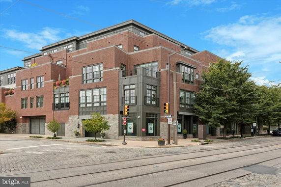 Front view of a multi-story brick building on a street corner.