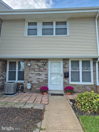 Front view of a two-story townhouse with brick and siding exterior.