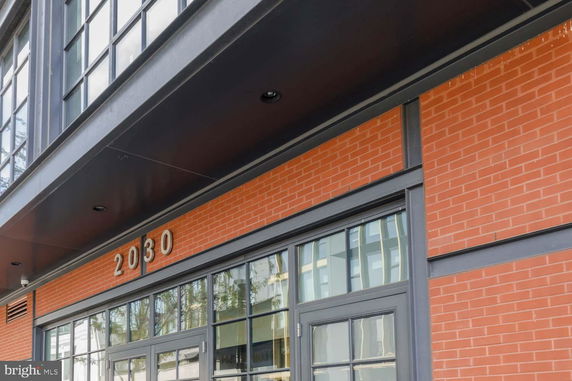 Front view of a building with brick facade and large windows.