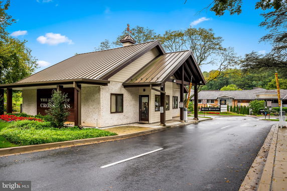 Front view of a single-story building with a metal roof and entrance overhang.