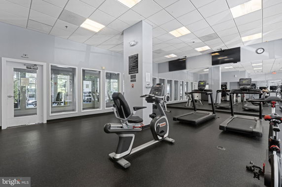 Interior view of a gym with exercise equipment including treadmills and stationary bikes.