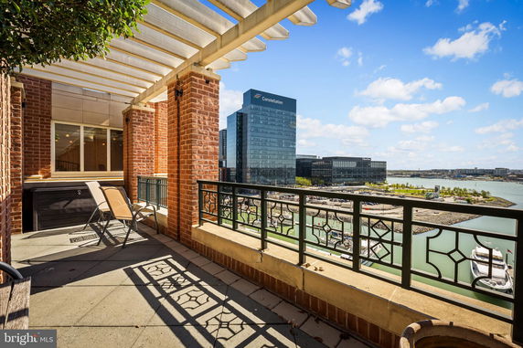 Outdoor terrace with a view of city buildings and a water body.