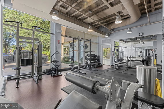 Indoor gym area with workout equipment including weight machines and benches.