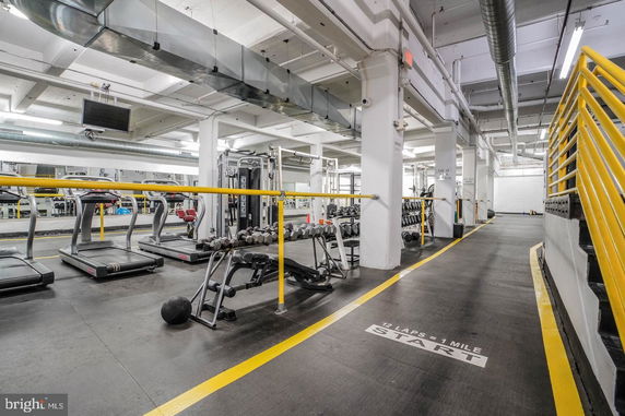 Interior view of an indoor gym with exercise equipment and a track.