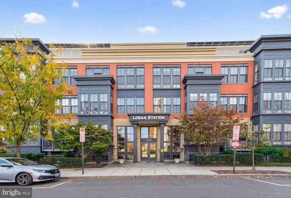 Front view of a multi-story building with large windows and a sign reading 'Logan Station' above the entrance.