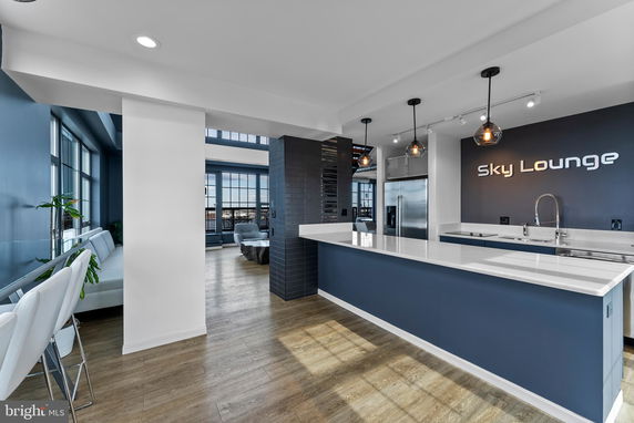 Interior view of a lounge area with modern decor and kitchen amenities.