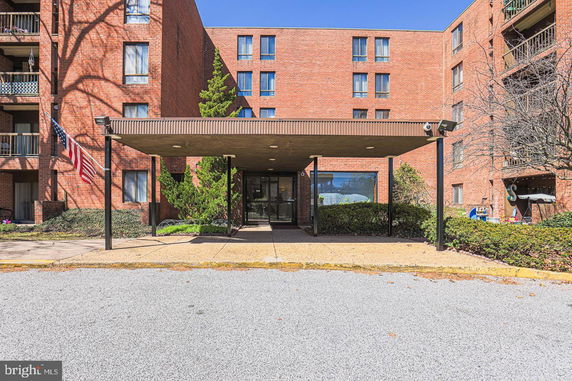Front view of a multi-story brick building with a covered entrance.