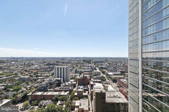 Wide-angle view of urban landscape from a high vantage point, including buildings and cityscape.