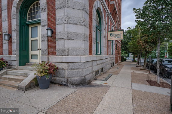 Front view of a brick building with a stone facade and arched doorways.