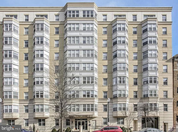 Front view of a multi-story residential building with bay windows.