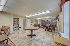 Room with bookshelves and tables, chairs arranged for recreational activities