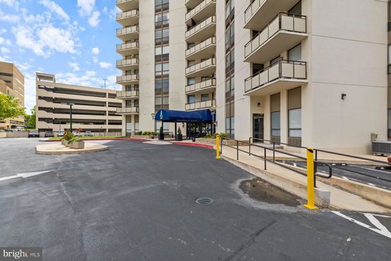 Front view of a multi-story building with balconies and a covered entrance.