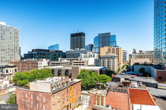 Panoramic view of a cityscape with various buildings under a clear blue sky.