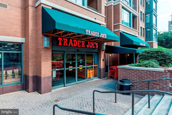 Front view of a building entrance with a green awning and a glass door.