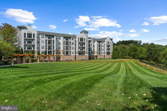 Front view of a multi-story residential building with surrounding greenery.
