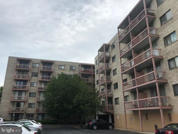 Front view of a multi-story apartment building with balconies.