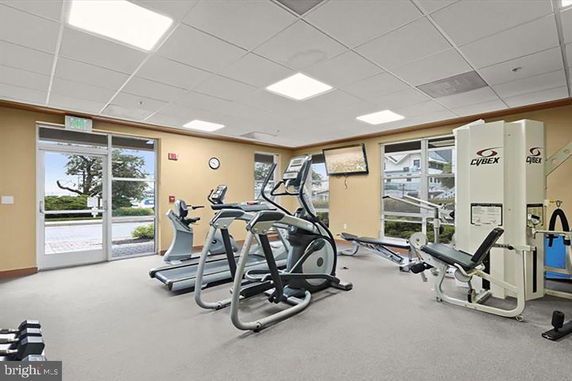 Indoor gym area with exercise equipment and large windows.