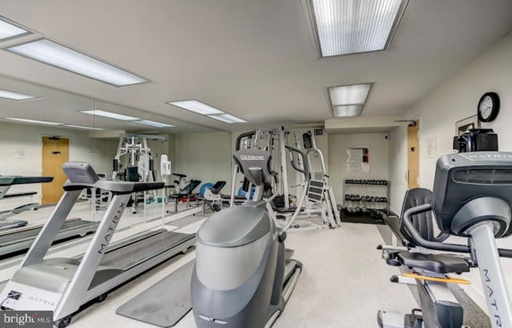 Indoor gym area with exercise equipment and mirrored walls.