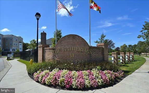 Front view of a building complex entrance with signage and flags.