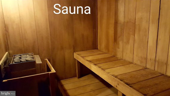 Interior view of a wooden sauna with benches and a heater.