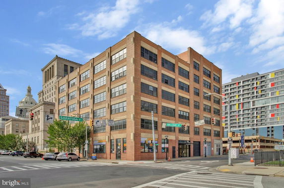 Front view of a multi-story brick building at an urban intersection.