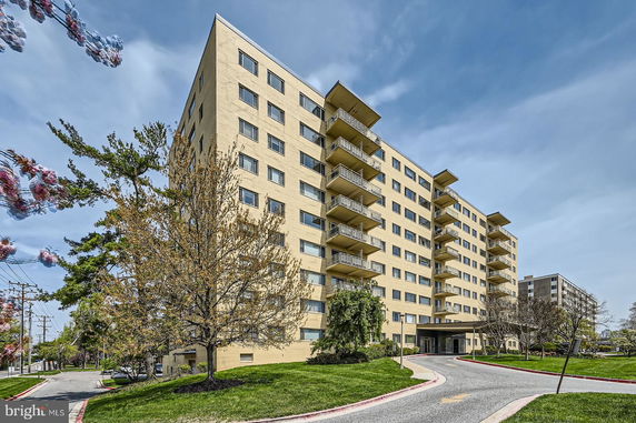 Front view of a multi-story apartment building with balconies.