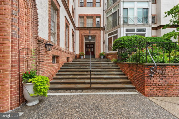Front view of a building with brick walls and stairway entrance.