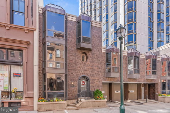 Front view of a building with brown brick facade and multiple large windows.