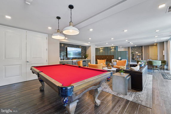 Indoor recreation room with a billiards table and seating area.