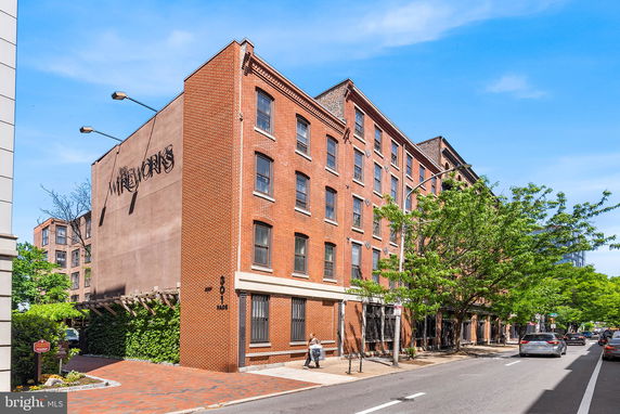 Front view of a multi-story brick building on a city street.