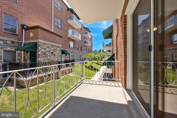 View of multi-story brick residential building with balconies and awnings.
